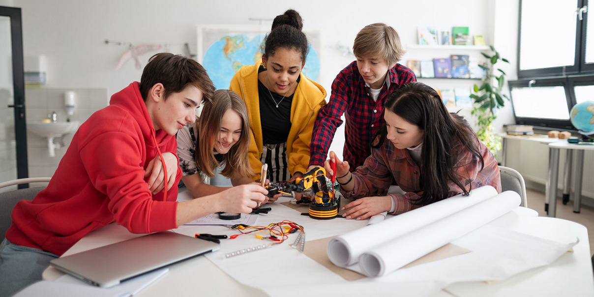 Group of students working together on a robotics project in a classroom.