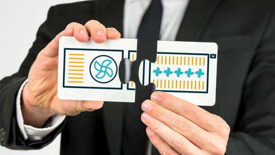 Businessperson holding two puzzle pieces symbolising the connection between heat pumps and radiators.